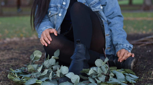 Girl sitting in leaves with black tights on