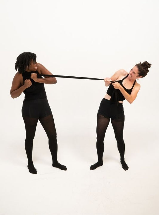 Two women are pulling the black tights from CLOECO brand, showing its flexable texture and durable long lasting. High quality, comfortable and also ecofriendly. 