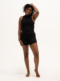 A woman is wearing a pair of black boyshort underwear. The texture is soft and cozy.